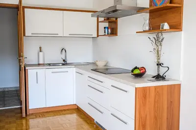 a kitchen with white cabinets and a sink at Apartments Vila Lena at Aqualuna in Podčetrtek