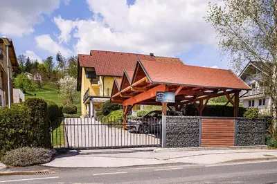 a house with a wooden gazebo on the street at Apartments Vila Lena at Aqualuna in Podčetrtek
