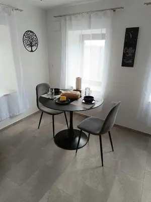 a table and two chairs in a room with a table and a table and chairs at Sivka - mountain apartment with sauna in Kobarid