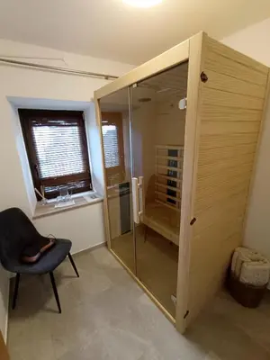 a shower with a glass door in a room at Sivka - mountain apartment with sauna in Kobarid
