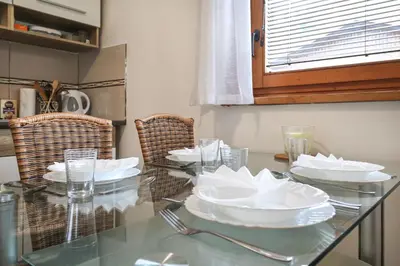 a glass table with white dishes on top of it at Aqualuna Olimia Vacation Home in Podčetrtek