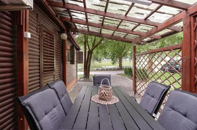 a wooden table and chairs on a patio at Aqualuna Olimia Vacation Home in Podčetrtek