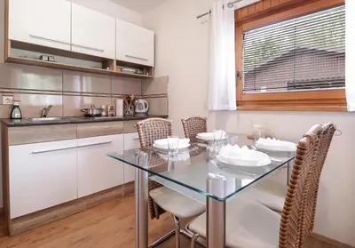 a dining room with a glass table and chairs at Aqualuna Olimia Vacation Home in Podčetrtek