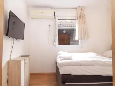 a small room with two beds and a television at Aqualuna Olimia Vacation Home in Podčetrtek