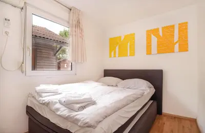 a bed in a room with a window at Aqualuna Olimia Vacation Home in Podčetrtek