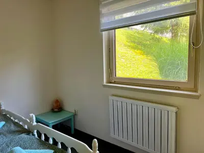 a bedroom with a window and a green table at Relax in nature Apartment in Bovec
