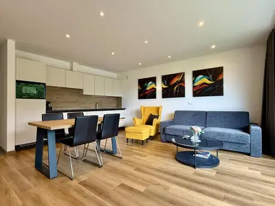 a living room with a blue couch and a table at Vila Katarina - Lake View Apartments in Bled