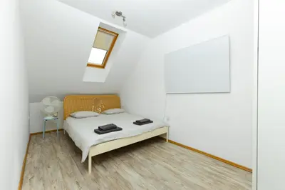 a white bedroom with a bed and a mirror at Svarun apartment in Bovec