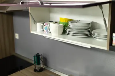 a shelf with plates and other dishes on it at Svarun apartment in Bovec