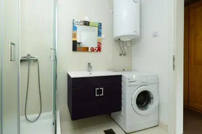 a bathroom with a washing machine and a sink at Svarun apartment in Bovec