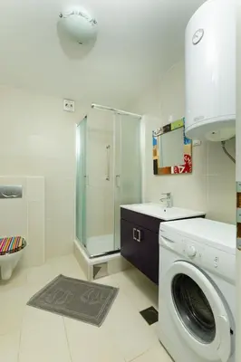 a bathroom with a washing machine and a shower at Svarun apartment in Bovec
