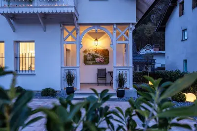 a home with a lit up front porch with plants at Vila Mignon in Bled