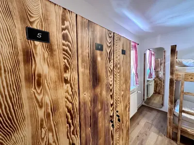 a row of wooden lockers in a bedroom at Bajta Kroparica in Kropa
