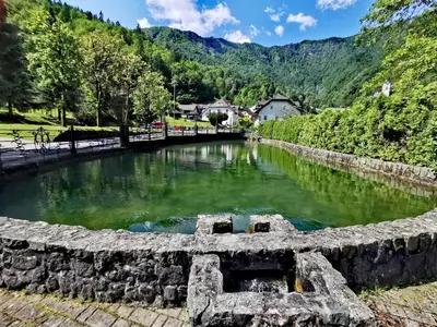 a pool of water with mountains in the background at Bajta Kroparica in Kropa