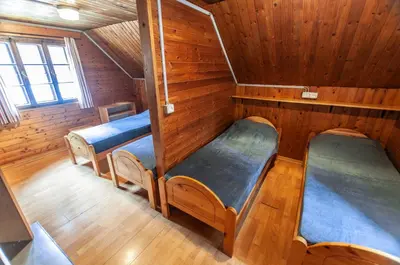 a room with three bunk beds in a cabin at Mala koča Wooden Cabin in Goreljek