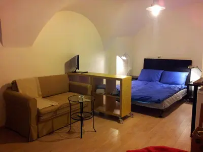 a living room with a couch and a bed at Studio Ian in Ljubljana