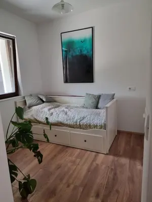 a bedroom with a bed with a picture on the wall at Hiša Rožmarin in Osp
