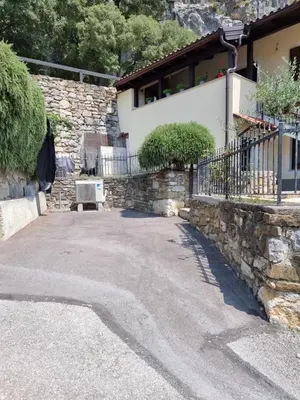 a house with a stone wall and a bench at Hiša Rožmarin in Osp