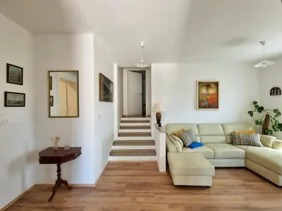 a white living room with a couch and a table at Hiša Rožmarin in Osp