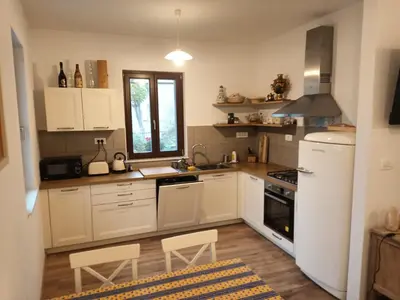 a kitchen with white cabinets and a white refrigerator at Hiša Rožmarin in Osp