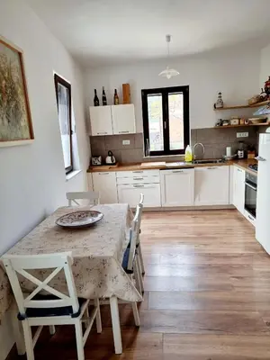 a kitchen with a table and chairs in a room at Hiša Rožmarin in Osp