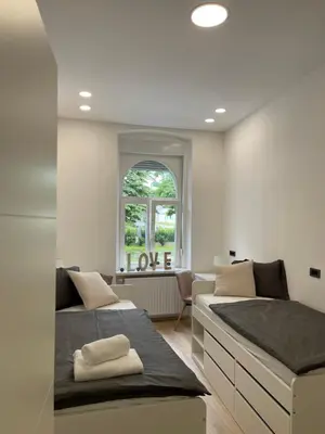 two beds in a room with a window at City Apartment Chiara in Maribor