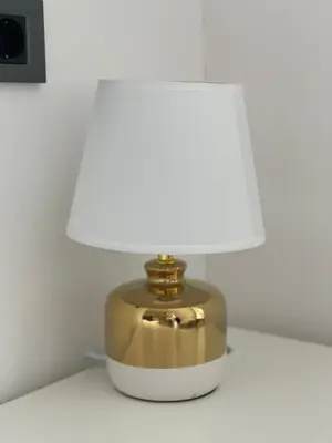 a gold and white lamp sitting on a table at City Apartment Chiara in Maribor