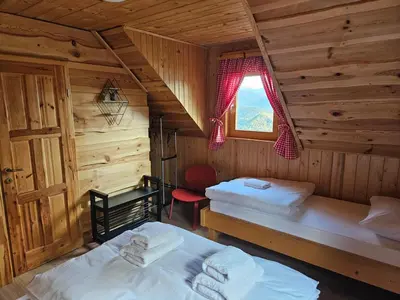 a bedroom with two beds in a log cabin at Koča na Taležu in Bled