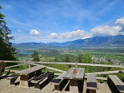 a picnic table on top of a mountain with a view at Koča na Taležu in Bled