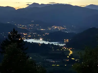 a view of a city and a river at night at Koča na Taležu in Bled