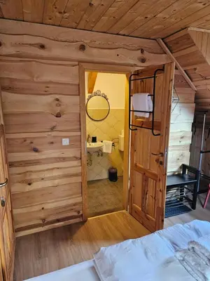 a room with a bedroom with a bed and a bathroom at Koča na Taležu in Bled