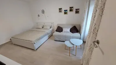 a small bedroom with a bed and a table at Apartma Rižana in Dekani