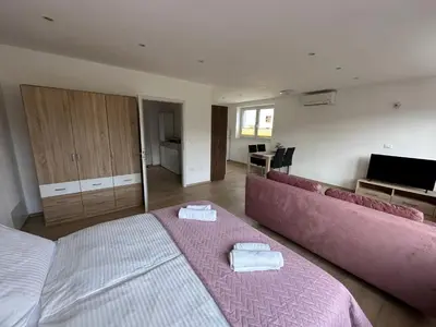 a bedroom with two beds and a pink couch at Apartma ALTA in Tolmin