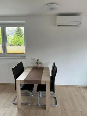 a dining room with a wooden table and black chairs at Apartma ALTA in Tolmin