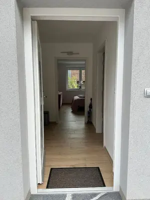 a hallway with a door open to a living room at Apartma ALTA in Tolmin