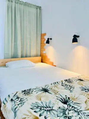 a bedroom with a bed with a blue and white comforter at Sunny app in Ljubljana