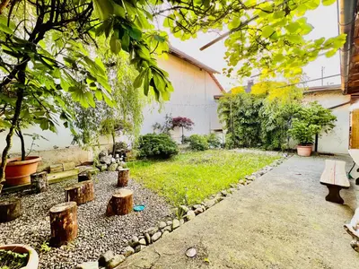 a garden with trees and benches and a building at Sunny app in Ljubljana
