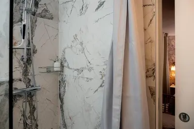 a bathroom with a marble wall and a shower curtain at New Cute Studioapartment in Ljubljana + Free bikes in Ljubljana