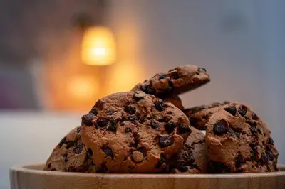 three chocolate cookies sitting on a plate at New Cute Studioapartment in Ljubljana + Free bikes in Ljubljana