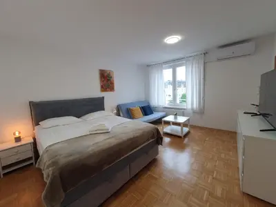 a bedroom with a bed and a chair and a window at Apartment Zala with free parking Tour As Ljubljana in Ljubljana