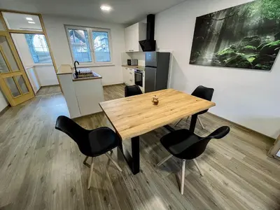 a dining room with a wooden table and black chairs at Apartment Neli in Rečica ob Savinji