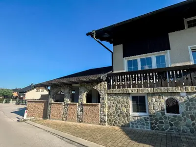 a stone building with a wooden fence on a street at Apartment Neli in Rečica ob Savinji