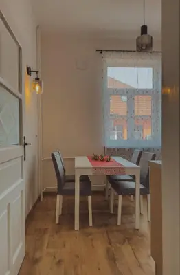 a dining room with a table and chairs and a window at Pirc apartment on Dunajska street in Ljubljana