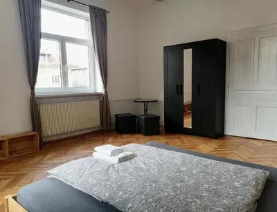 a bedroom with a bed and a large window at Pirc apartment on Dunajska street in Ljubljana