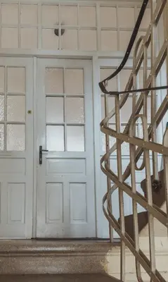 a white door and stairs in a room at Pirc apartment on Dunajska street in Ljubljana