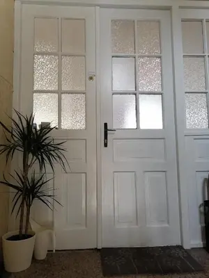 a white door with a potted plant next to it at Pirc apartment on Dunajska street in Ljubljana