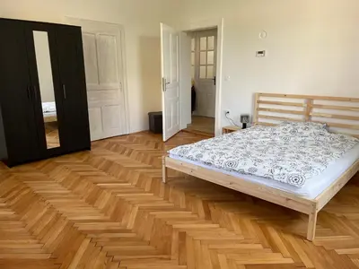 a bedroom with a bed and a wooden floor at Pirc apartment on Dunajska street in Ljubljana