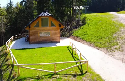 a small cabin on a grassy hill with a fence at Bled Straza House in Bled