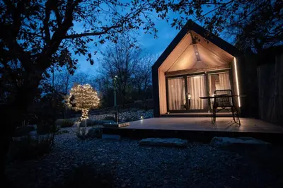 a tiny house with a chair on a deck at night at Moon - Tiny house from Callin Wines in Sežana