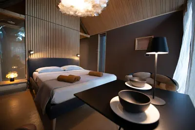 a bedroom with a bed and a table with a table sidx sidx sidx at Moon - Tiny house from Callin Wines in Sežana